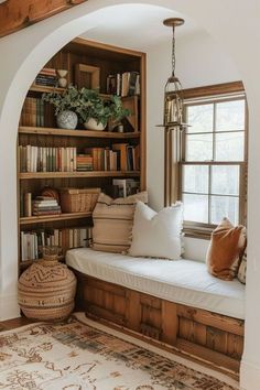 a window seat with bookshelves and pillows in the corner, next to a rug