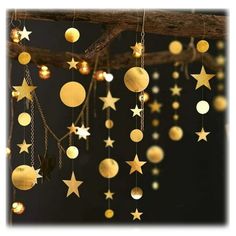 some gold stars hanging from a branch with lights on it's sides and chains attached to the branches