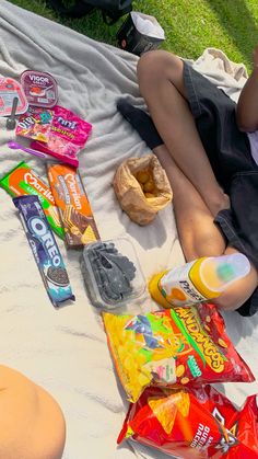 a person laying on a blanket with snacks