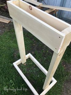 an unfinished wooden table sitting in the grass