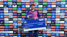 a man standing on top of a tennis court holding a giant check