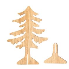 a wooden cutout of a pine tree next to a pair of scissors on a white background