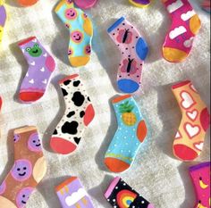 several pairs of colorful socks are laid out on the ground with hearts and clouds painted on them