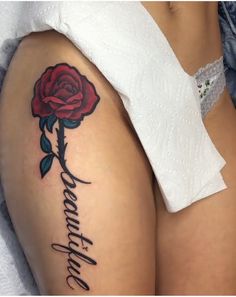 a woman's thigh with a rose tattoo on it and the word love written in cursive writing