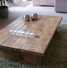 a wooden coffee table sitting on top of a green rug