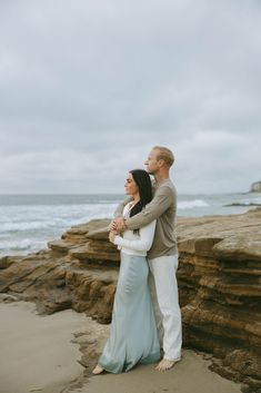 a man and woman embracing on the beach