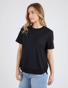 DESCRIPTION Elevate your everyday wardrobe with the Farrah Short Sleeve Tee in Black by Foxwood. This essential tee is designed with a classic crew neckline and short sleeves, offering a timeless look that can be dressed up or down. Made from a soft, breathable cotton blend, it ensures comfort and durability. The relaxed fit and ribbed hem detail add a touch of style to this versatile piece, making it a must-have for any wardrobe. Pair the Farrah Short Sleeve Tee with denim shorts and white snea 50 Fashion, New T, Everyday Wardrobe, Casual Wardrobe, Pima Cotton, Raw Edge, Long Sleeve Tee, Black Tee, Crew Neckline