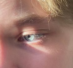 a close up of a person's face with the sun shining on their eyes