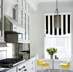 a kitchen with black and white checkered flooring, yellow chairs and a table