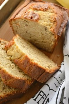 sliced loaf of banana bread sitting on top of a wooden cutting board