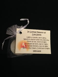 a small memorial candle with a ribbon around it on a black background that says, in loving memory of lily smith