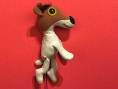 a stuffed animal hanging on a red wall