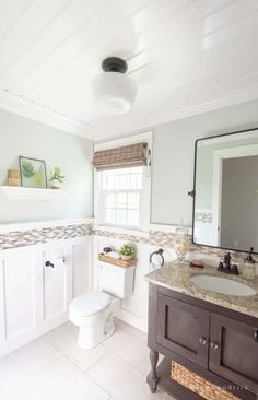 a bathroom with a toilet, sink and mirror in it's centerpieces