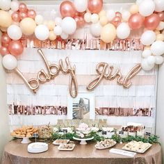 a baby girl party with balloons and desserts