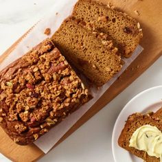 two slices of banana bread on a cutting board next to a plate with some bananas