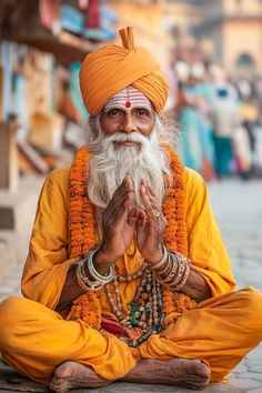 an old man sitting on the ground with his hands clasped in front of his face