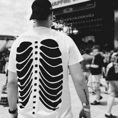 a man wearing a t - shirt with a skeleton print on it's back