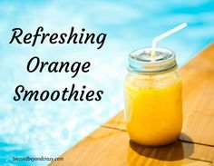 a mason jar filled with yellow liquid sitting on top of a wooden table next to a swimming pool