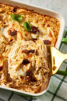 a casserole dish with meat and cheese in it on a green checkered cloth