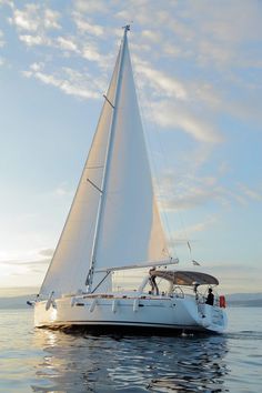 a white sailboat floating on top of the ocean