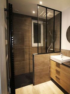 a bathroom with a sink, mirror and shower stall in the middle of it's wall