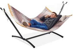 a man laying in a hammock talking on the phone