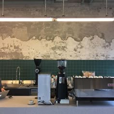 a man sitting at a table working on his laptop in front of a coffee maker