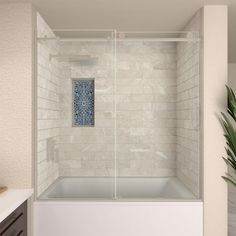 a bathroom with white tile walls and a glass shower door that opens up to the bathtub