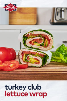 two sandwiches cut in half sitting on top of a cutting board next to tomatoes and lettuce