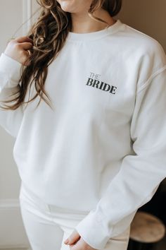 Our Woodrose White Bride Jumper is the perfect piece for any soon-to-be bride. This on trend jumper combines style and comfort, making it ideal for pre-wedding festivities or a relaxing bridal shower. A thoughtful gift for the bride or a stylish accessory for your bridal event. Sizing: (Please see size chart in product photos) True to size - if you like an oversized fit we recommend sizing up. Product Details: - Made with a medium-heavy fabric blend of 50% cotton and 50% polyester , this sweatsh Wedding Getting Ready Sweatshirt, Bride Jumper, Bride Sweatshirt Wedding Day, Bride Sweats, Bride Hoodie Sweatshirts, Bride To Be Sweatshirt, Bride Sweatshirt, Gift For The Bride, Wedding Festivities