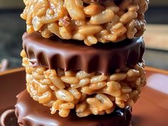 three stacked chocolate covered desserts sitting on top of each other, with macaroni and cheese in the middle