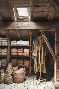 a room filled with lots of different types of blankets and baskets on top of wooden flooring