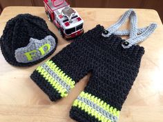 a crocheted hat, sweater and toy car on a table