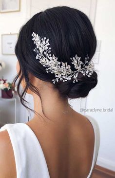 the back of a woman's head wearing a bridal hair comb with leaves on it