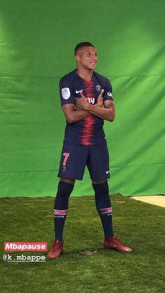 a soccer player standing in front of a green screen with his arms crossed and hands folded