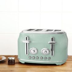 a green toaster sitting on top of a wooden counter