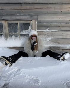 a woman sitting in the snow with her feet up