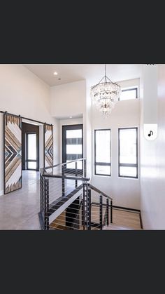 an open floor plan with stairs and chandelier