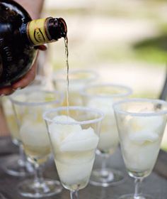 a person pours wine into glasses filled with ice