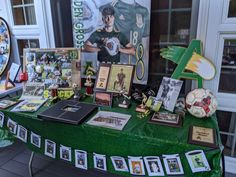 a green table topped with pictures and memorabilia