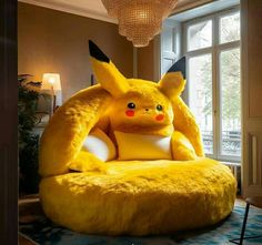 a large stuffed pikachu sitting on top of a chair