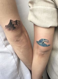 two people with matching tattoos on their arms and legs, one has a wave tattoo on the other arm