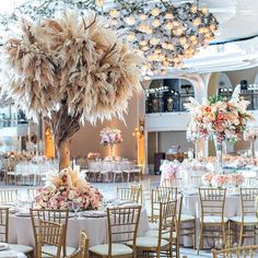 the tables are set up with gold chairs and centerpieces for an elegant wedding reception