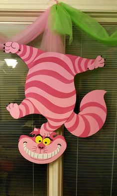 a pink and green decoration with a cartoon cat on it's head hanging from a pole