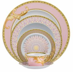 a pink and gold dinner set with an ornate design