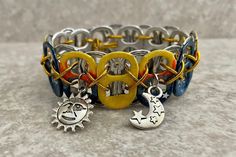 a close up of a bracelet on a table with two charms and an object in the middle