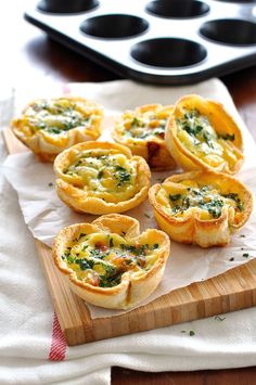 mini quiches with spinach and cheese on a cutting board