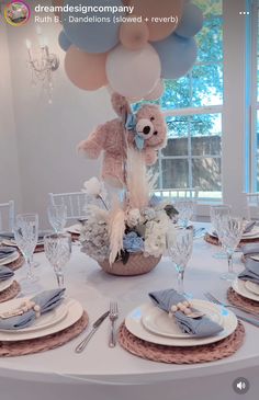 a table set up for a baby's first birthday party with balloons and flowers