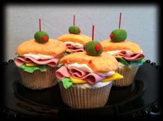 cupcakes decorated with icing and toppings on a black plate