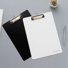 a clipboard with a black and white paper attached to it next to a pen